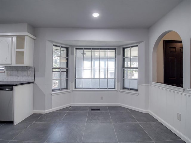 unfurnished dining area with dark tile patterned floors