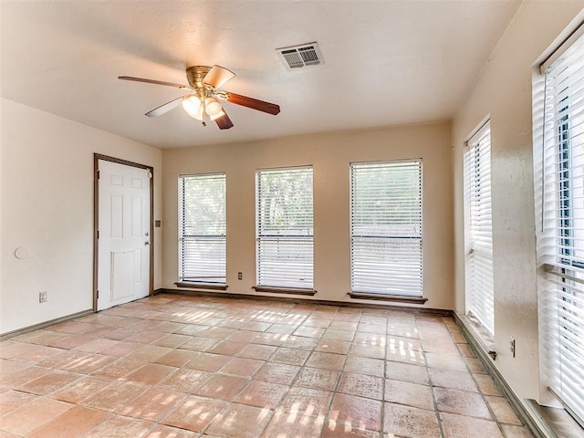 empty room with ceiling fan and a healthy amount of sunlight