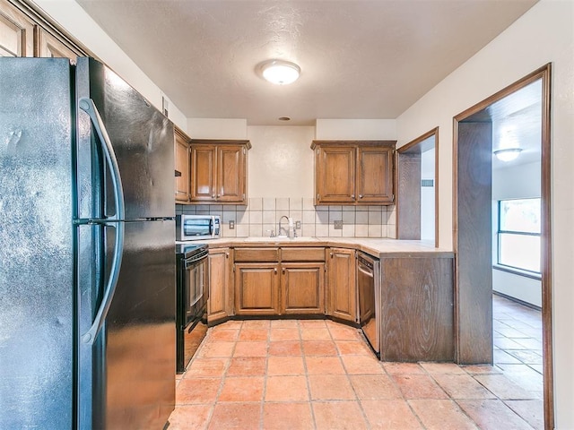 kitchen featuring backsplash, sink, and black appliances