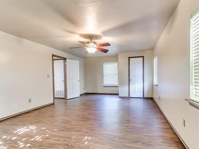 empty room with ceiling fan and wood-type flooring