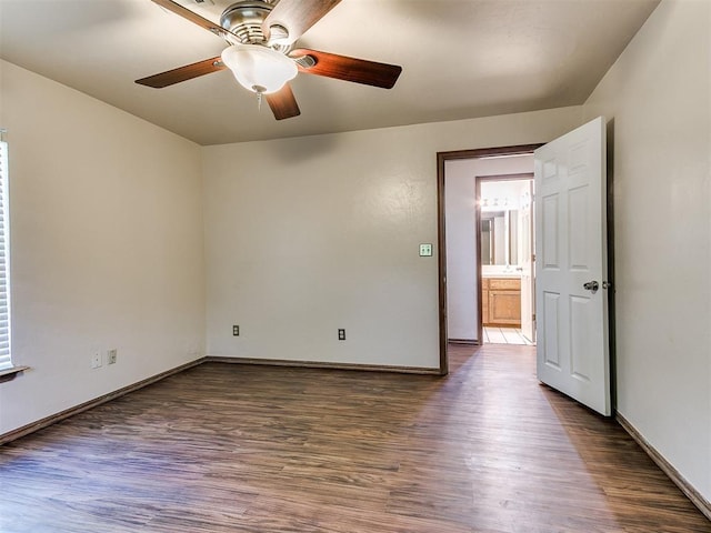 empty room with ceiling fan and dark wood-type flooring