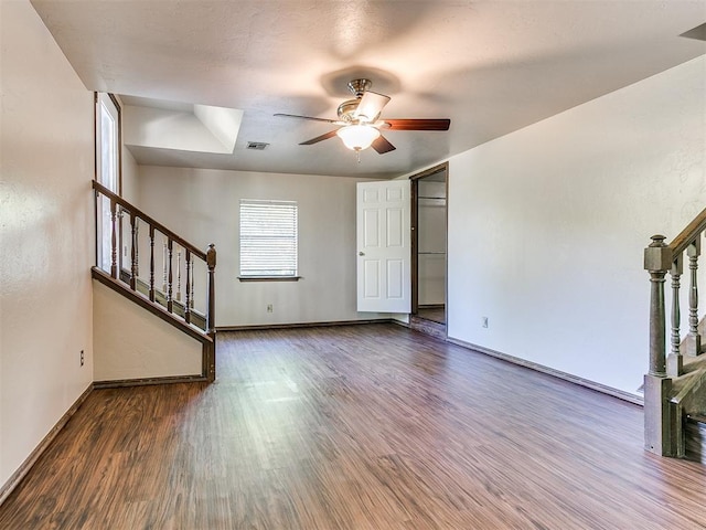 unfurnished living room with ceiling fan and dark hardwood / wood-style flooring