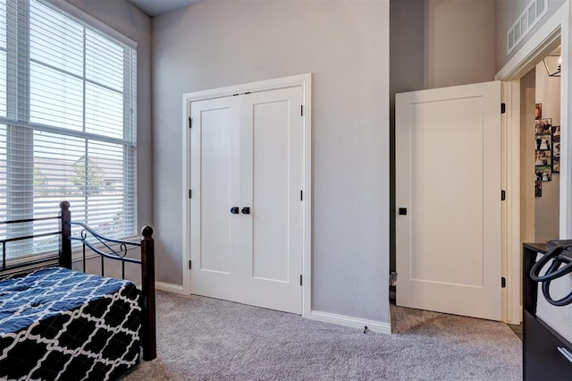 bedroom featuring light carpet and a closet