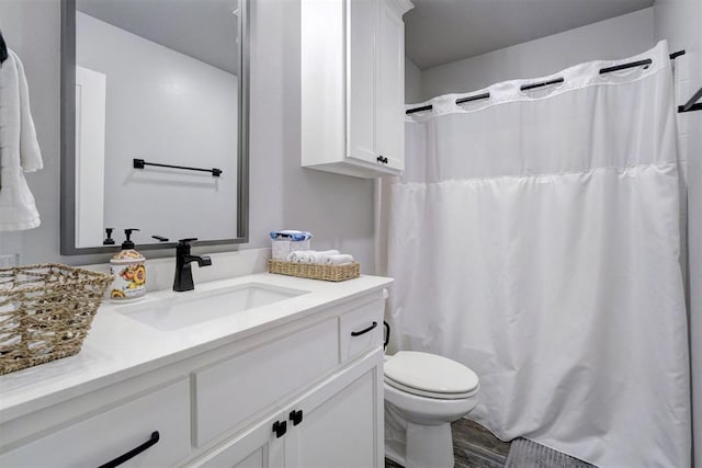 bathroom featuring hardwood / wood-style floors, vanity, curtained shower, and toilet