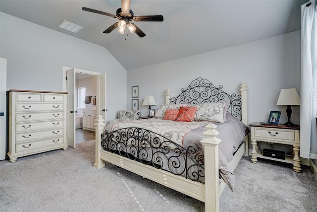 bedroom featuring ceiling fan, ensuite bath, carpet floors, and vaulted ceiling