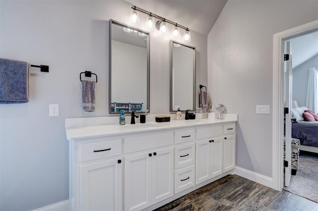 bathroom with wood-type flooring, vanity, and lofted ceiling