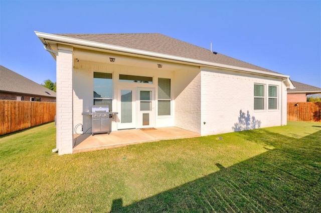 back of house featuring a lawn and a patio area