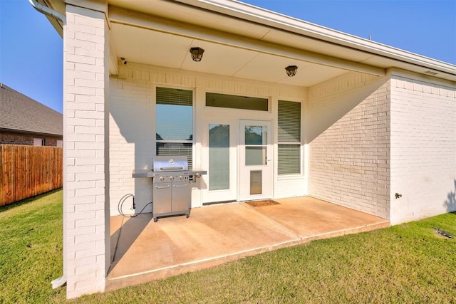 entrance to property featuring a patio area and a yard