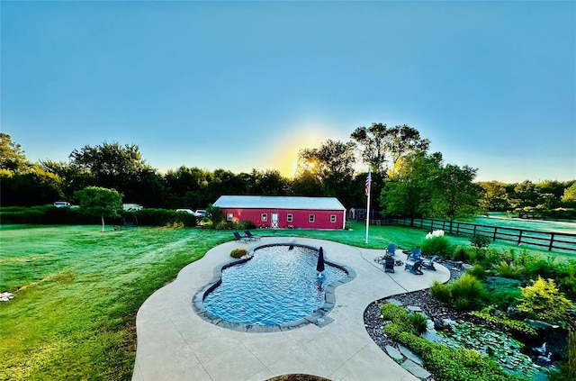 view of swimming pool with a yard, a patio area, and an outdoor structure