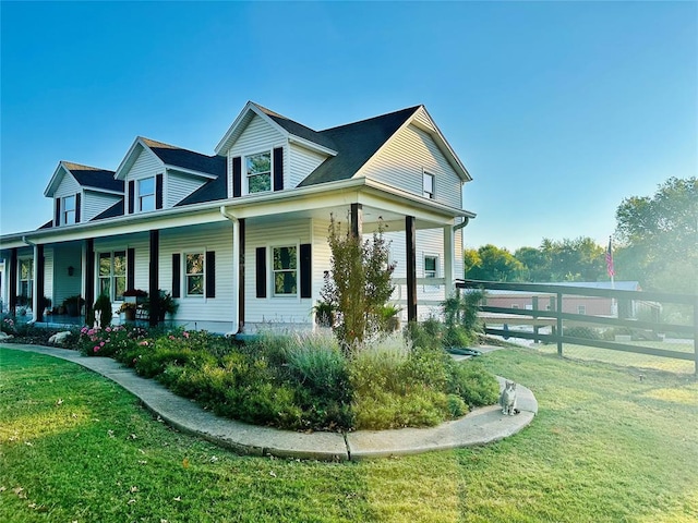 view of side of property with covered porch and a lawn