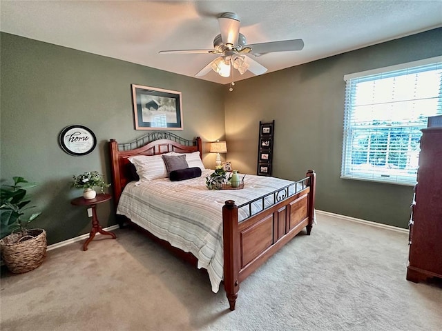 bedroom with ceiling fan and light colored carpet