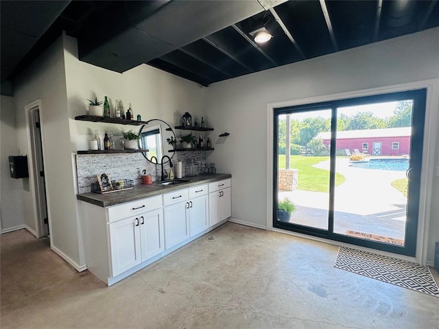 kitchen with white cabinets, backsplash, and sink