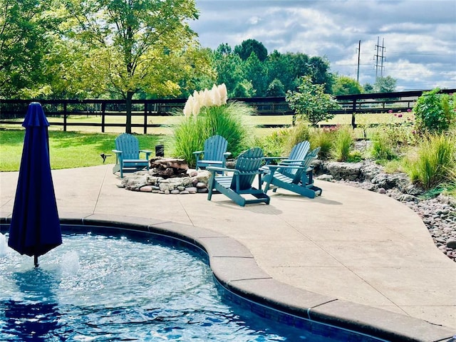 view of swimming pool with a patio area and an outdoor fire pit