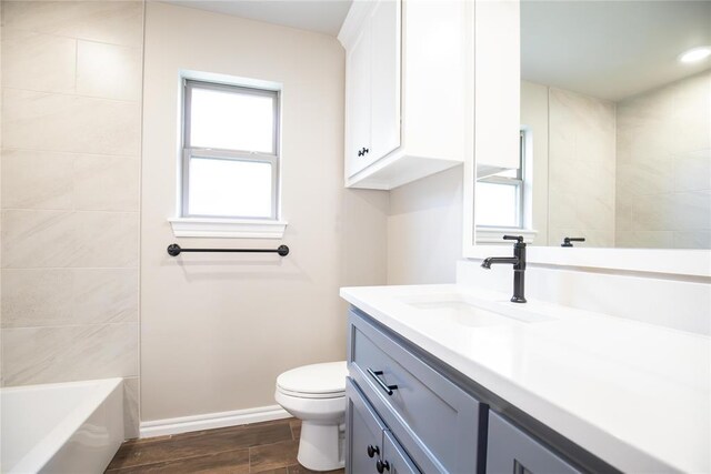 9309 Cheek Ranch Rd, Yukon, OK 73099 - full bathroom with vanity, wood finished floors, toilet, a tub, and a wealth of natural light