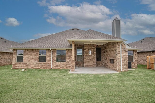 9309 Cheek Ranch Rd, Yukon, OK 73099 - back of house featuring a chimney, brick siding, a yard, a patio, and a shingled roof