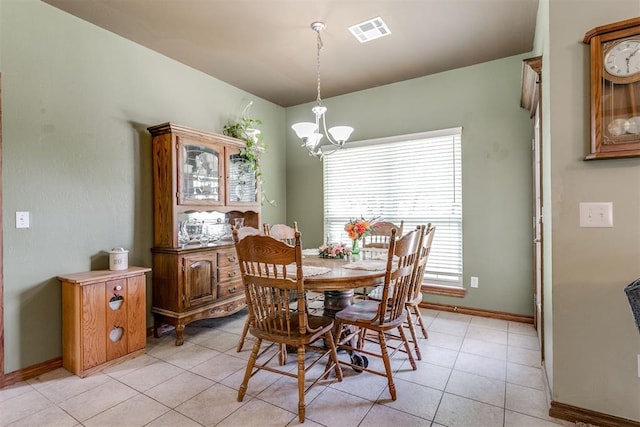 tiled dining area featuring an inviting chandelier