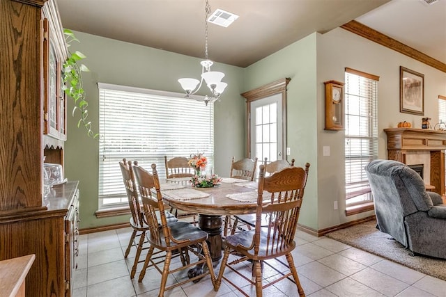 dining area featuring a chandelier, a wealth of natural light, a fireplace, and light tile patterned flooring