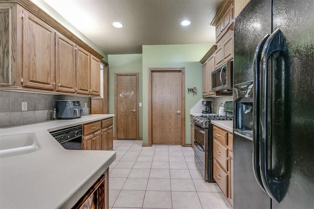 kitchen featuring black appliances, light tile patterned floors, sink, and tasteful backsplash