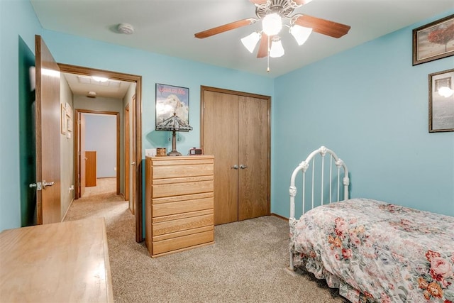 carpeted bedroom featuring ceiling fan and a closet