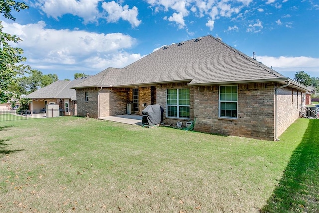 rear view of house with a lawn and a patio area