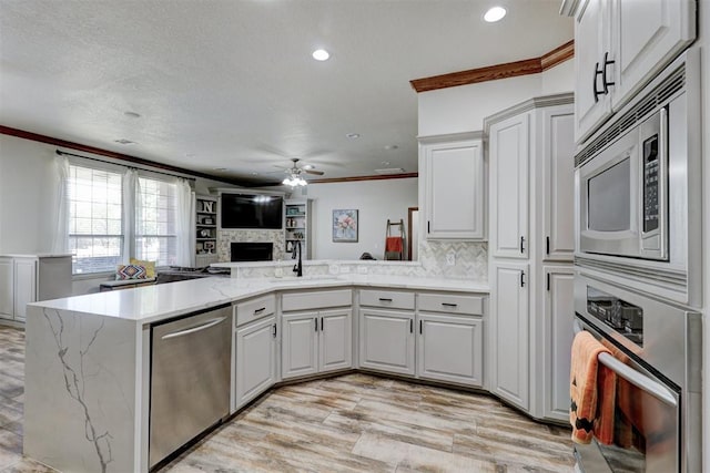 kitchen with kitchen peninsula, white cabinetry, and appliances with stainless steel finishes