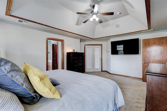 carpeted bedroom with a closet, a tray ceiling, ensuite bath, and ceiling fan