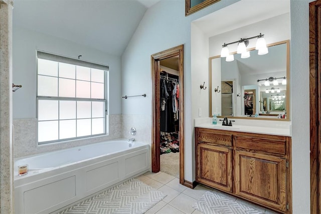 bathroom with tile patterned flooring, vanity, lofted ceiling, and a washtub