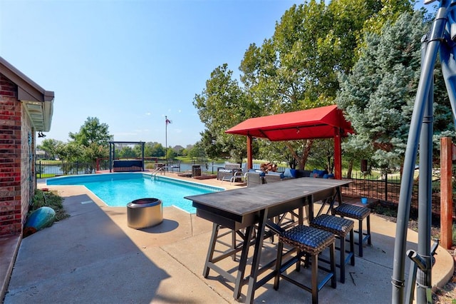 view of swimming pool with a water view and a patio area