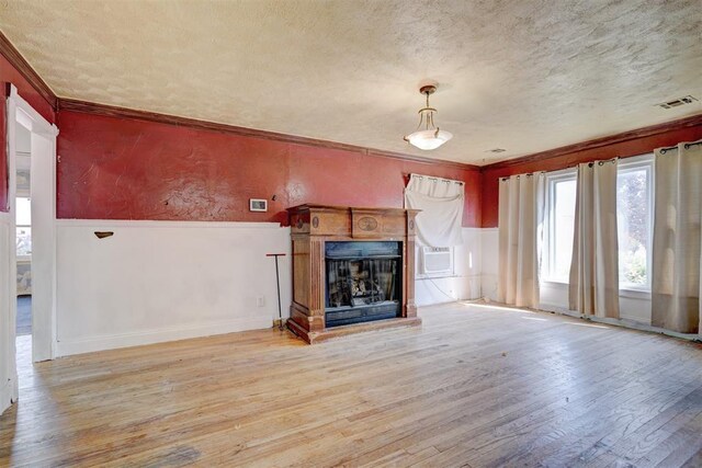 1413 Reding Dr, Oklahoma City, OK 73119 - unfurnished living room with a textured ceiling, hardwood / wood-style floors, a fireplace, crown molding, and a wainscoted wall