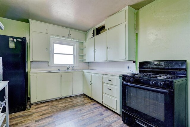 1413 Reding Dr, Oklahoma City, OK 73119 - kitchen with black appliances, light countertops, open shelves, light wood-type flooring, and white cabinets