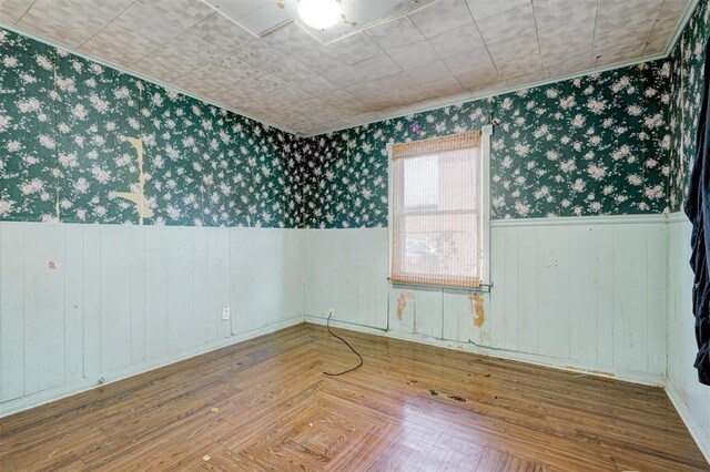 1413 Reding Dr, Oklahoma City, OK 73119 - unfurnished room featuring wallpapered walls, wainscoting, ornamental molding, and wood finished floors