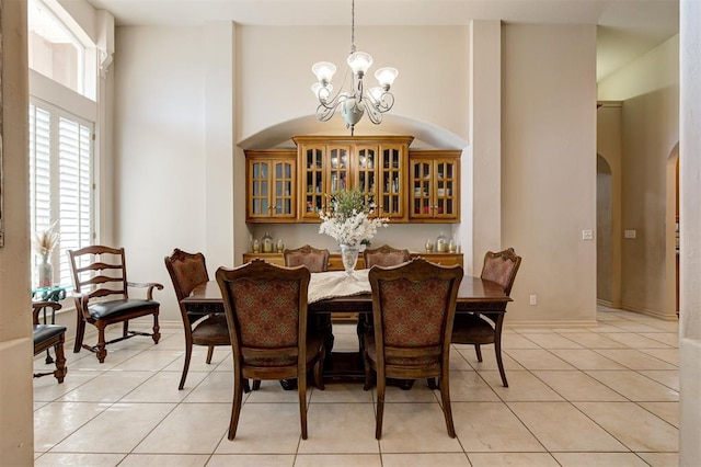 tiled dining room with a notable chandelier