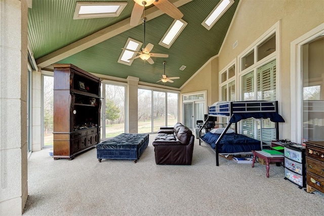 interior space featuring beam ceiling, a skylight, ceiling fan, and high vaulted ceiling