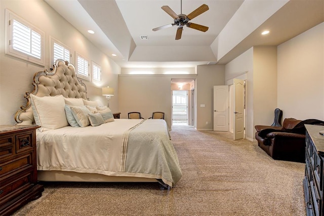 bedroom with carpet flooring, ceiling fan, and a tray ceiling