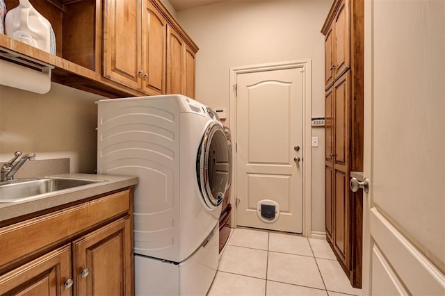 washroom with washing machine and clothes dryer, light tile patterned floors, cabinets, and sink