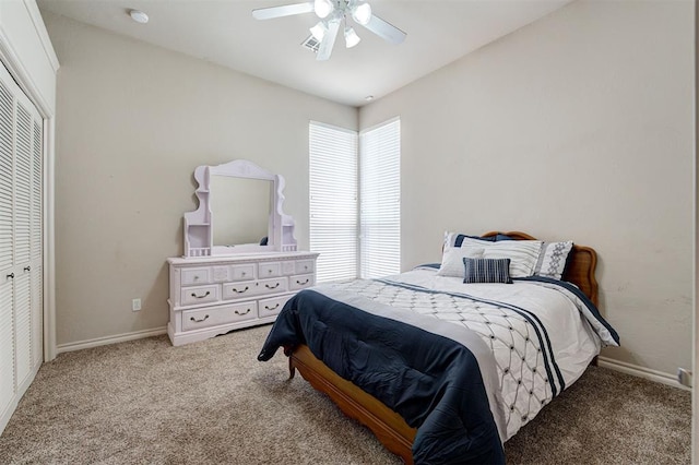 bedroom with ceiling fan, light colored carpet, and a closet