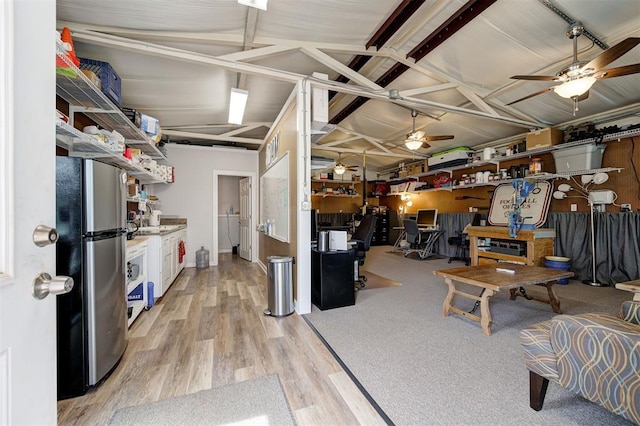 interior space featuring ceiling fan, stainless steel refrigerator, and light hardwood / wood-style flooring