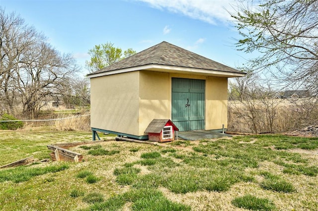 rear view of property with an outbuilding and a lawn