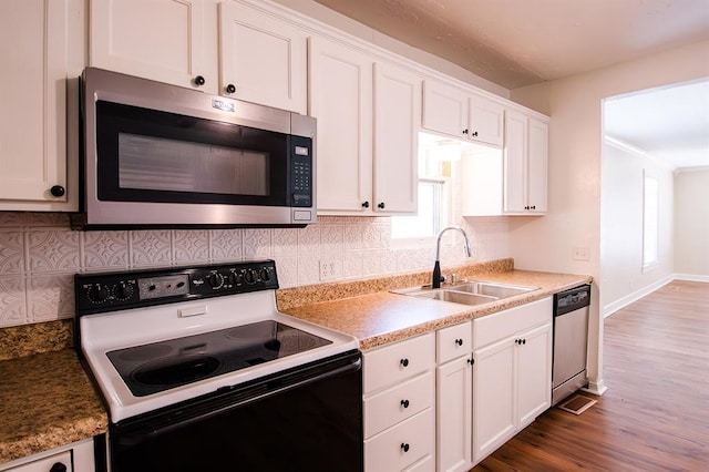 kitchen featuring appliances with stainless steel finishes, white cabinetry, and sink