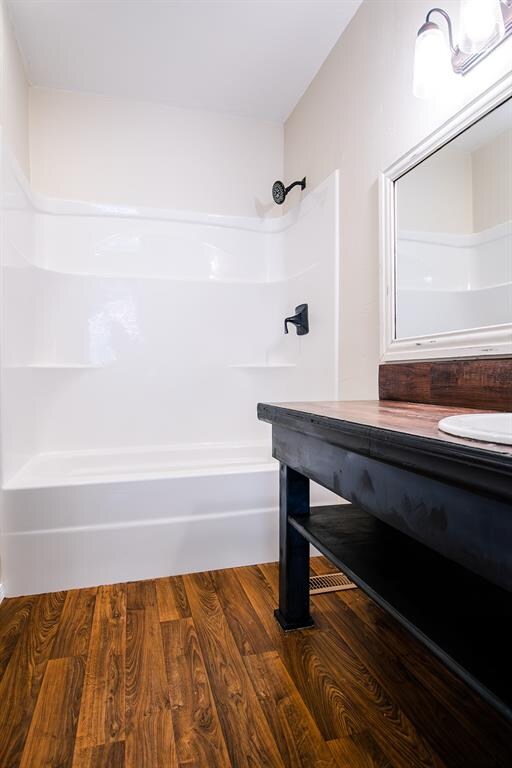 bathroom featuring vanity, wood-type flooring, and bathtub / shower combination