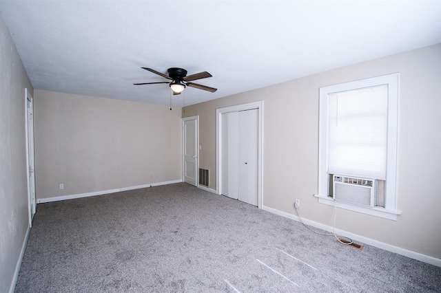 unfurnished bedroom with carpet, ceiling fan, cooling unit, and two closets