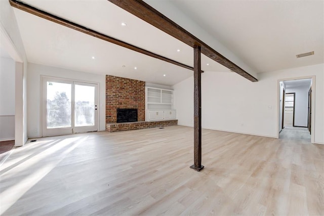 900 Woodbury Dr, Edmond, OK 73034 - unfurnished living room featuring beamed ceiling, a brick fireplace, and light wood-style flooring