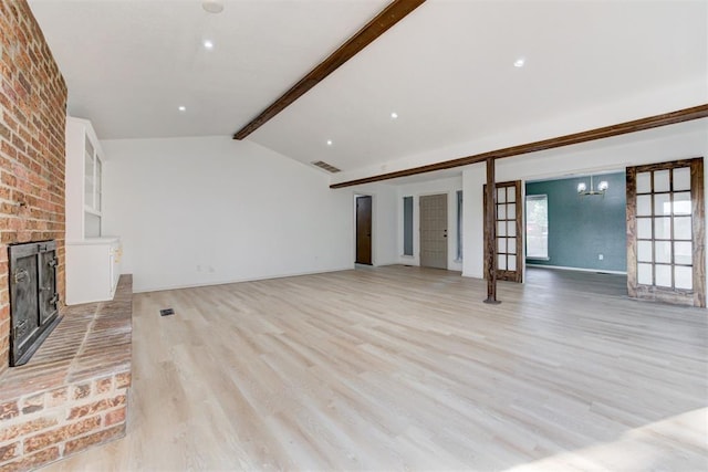 unfurnished living room featuring a fireplace, french doors, lofted ceiling with beams, and light hardwood / wood-style flooring