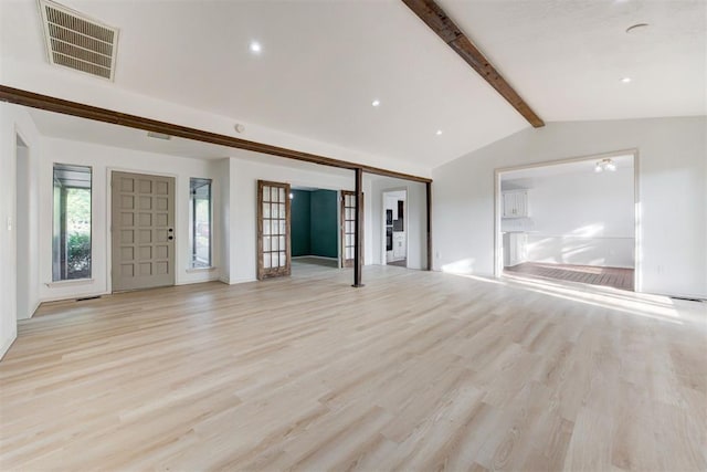 unfurnished living room featuring vaulted ceiling with beams, french doors, and light hardwood / wood-style floors