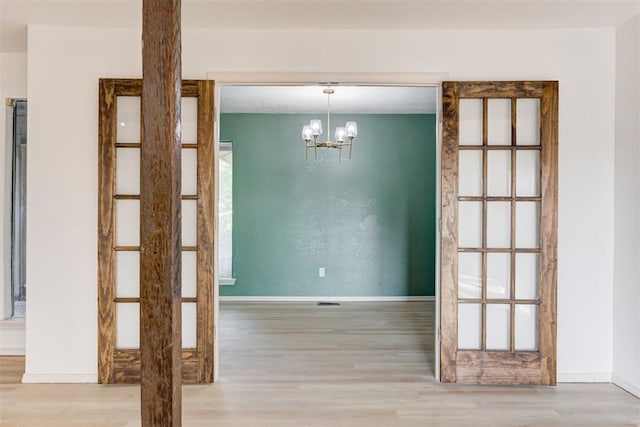 900 Woodbury Dr, Edmond, OK 73034 - unfurnished dining area featuring wood finished floors and a chandelier