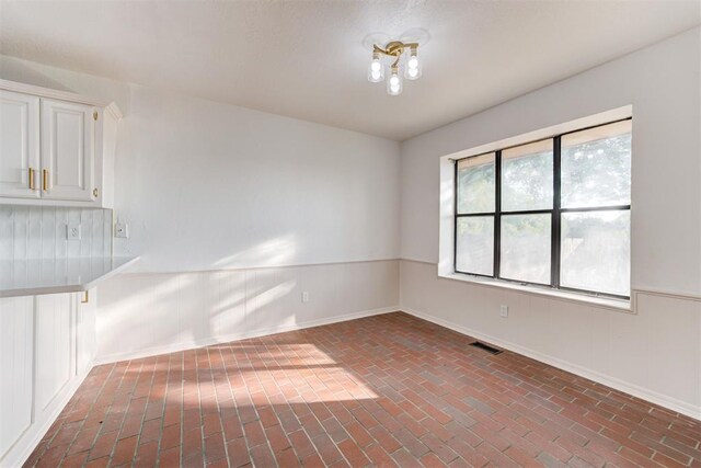 900 Woodbury Dr, Edmond, OK 73034 - empty room with brick flooring