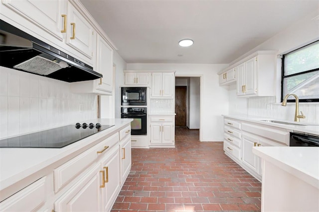 kitchen featuring tasteful backsplash, sink, white cabinets, and black appliances