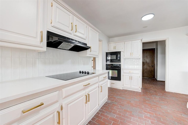 900 Woodbury Dr, Edmond, OK 73034 - kitchen with black appliances, under cabinet range hood, light countertops, decorative backsplash, and brick floors
