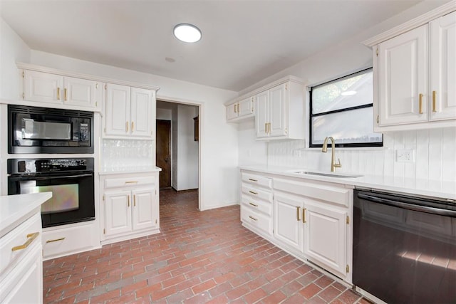 kitchen featuring sink, backsplash, white cabinetry, and black appliances