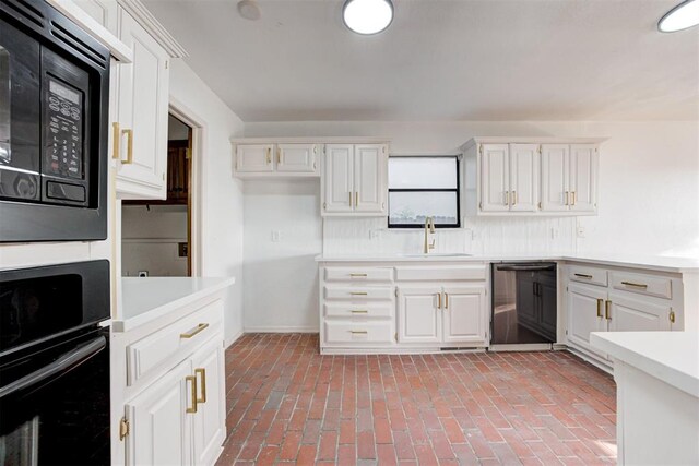900 Woodbury Dr, Edmond, OK 73034 - kitchen featuring dishwashing machine, black oven, light countertops, and white cabinetry